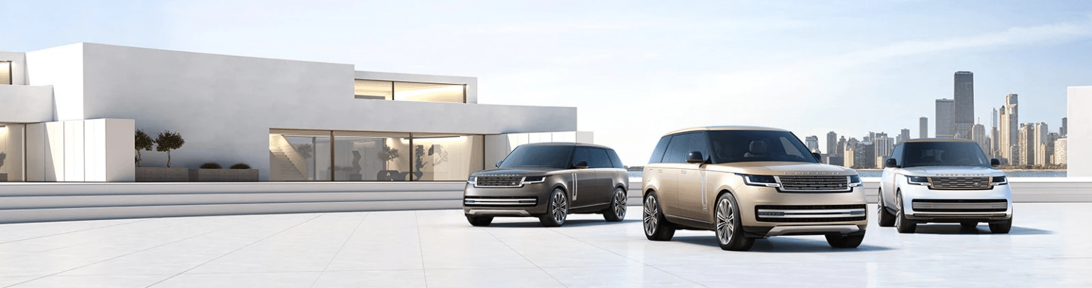 Three luxury SUVs are parked in front of a modern, minimalist building with large glass windows. The vehicles are positioned side by side, with the city skyline visible in the background